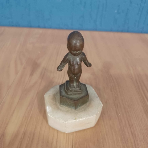 Pequena e rara estatueta em bronze representando um bebê de braços abertos