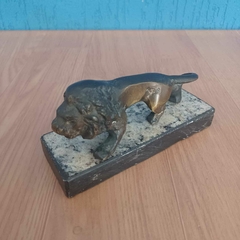 Escultura antiga de leão em bronze sobre base de mármore na internet