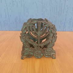 Peça em metal porta guardanapocomposto por uma menorá (candelabro judaico) envolta por ramo de oliveira - comprar online