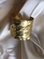 Pulsera grande de bronce con un diseño texturizado y acabado dorado 