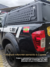 Capota Torden Adventure para Nissan Frontier 2024 instalada em uma caminhonete preta, destacando detalhes e acabamentos.