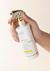 Frasco de Fluído Reparador Crono Shiny da Lief Cosmetic, com spray, segurado por uma mão feminina.