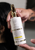 Frasco de Fluído Reparador Crono Shiny da Lief Cosmetic, em mãos, com rótulo detalhando benefícios como hidratação e proteção térmica.