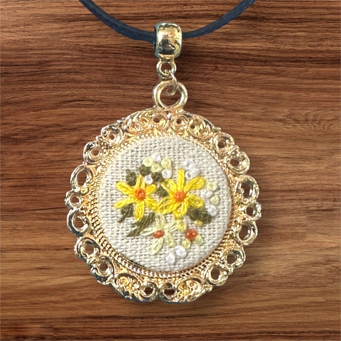 Colar charmoso com flores amarelas bordadas na medalha dourada com borda fio café - comprar online
