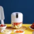 Mini triturador elétrico SmartElectric com alimentos variados ao redor, ideal para processar ingredientes na cozinha.