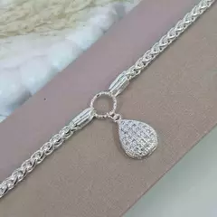 PULSEIRA ENTRELAÇADA COM PINGENTE CRAVEJADO FOLHEADA EM PRATA 925.