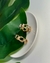  brinco apresenta um sofisticado design de elos entrelaçados em banho dourado, com delicados pontos de luz em zircônia cravejada, trazendo brilho na medida certa