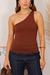 Mulher vestindo blusa feminina marrom de um ombro só e sem manga, combinada com calça jeans escura