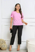 Modelo veste blusa feminina rosa de viscose com detalhes de flor na manga.