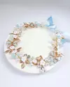 Tiara Amanda Azul para crianças, adornada com flores brancas, pérolas e detalhes dourados, sobre base circular. Tiara infantil Flexível, regulável e personalizável. Acessório Artesanal. Ateliê Mabelly Angels Celebre.