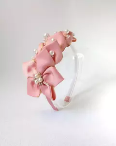Tiara Marina rosa, com flor de fita e detalhes em pérolas e strass, em fundo claro. Confeccionada em arco flexível e leve. Mabelly Angels Celebre.