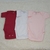 Kit com três bodies manga curta de bebê nas cores vermelho, branco e rosa claro.