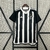 Camisa Atlético Mineiro Home 24/25 da Adidas, com design listrado em preto e branco, pendurada em um cabide.