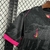 Camisa preta do Chelsea III 24/25 com detalhes em rosa, destacando o logo da Nike no ombro.