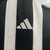 Detalhe da camisa Atlético Mineiro Home 24/25, mostrando o logo da Adidas em bordado branco sobre fundo preto.