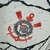 Emblema do Sport Club Corinthians Paulista em destaque na camisa branca e preta.
