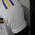 Detalhe da camisa do Boca Juniors 2, temporada 24/25, destacando as mangas brancas com listras azul e amarela.