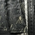 Detalhe da camisa Botafogo II 24/25 masculina, preta, mostrando o logo "Forjado no Fogo" e o design com linhas amarelas.