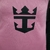 Detalhe do escudo do Inter Miami, em fundo rosa, com o logo em preto.