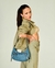 Modelo Larissa Manoela exibindo a Bolsa Meia Lua Jeans da coleção Up4You, usando uma roupa casual em tons de verde.
