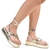 Sandálias femininas de plataforma com detalhes em dourado, mostrando apenas as pernas e os pés.