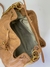 Interior de uma bolsa de couro bege, com detalhes em dourado e forro em tecido claro.