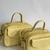 Conjunto de duas bolsas amarelas de couro com alças, uma maior e outra menor, em fundo neutro.