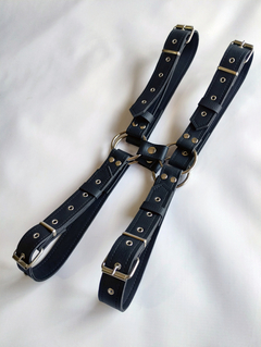 Arnés pectoral doble con aros niquelados, fabricado en cuero negro, ideal para prácticas BDSM.