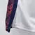 Camisa masculina branca para basquete, parte lateral com detalhes em vermelho e azul.