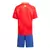 Kit infantil da Seleção da Espanha, composto por camisa vermelha e shorts azuis, visto de costas.