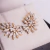 Brinco Earcuff folhas, ouro 18k, com brilhantes. na internet