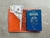 Carteira passaporte marrom aberta, exibindo um passaporte brasileiro e notas de dinheiro.