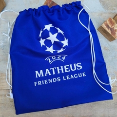 Saco azul com o nome "MATHEUS FRIENDS LEAGUE" e um símbolo de futebol com estrelas, ano 2024.