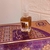 Frasco de perfume Decant Watani Al Wataniah Eau de Parfum 10ml sobre uma embalagem decorada.