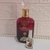 Frasco de perfume Sabah Al Ward Al Wataniah de 10ml ao lado do frasco maior, ambos com design elegante e detalhes em dourado.