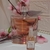 Frasco de perfume La Vie Est Belle da Lancôme ao lado de um decant de 10ml, decorado com flores e pérolas.