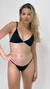 Modelo usando uma calcinha biquíni preta de fita, com um fundo neutro. Biquinis Versiani Swim fita, biquinis Panô, biquinis DKL.