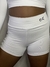 Shorts brancos de tecido leve, com uma cintura alta e detalhe de logo em um dos lados.