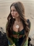 Modelo usando o Top Tule Górgona, com detalhes em verde e azul, em um cenário de praia.