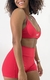 Sutiã Garnet vermelho com alças finas, modelo ajustado, usado por uma mulher sorridente.