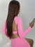 Modelo usando um top manga longa rosa, com uma aparência elegante e moderna, segurando um celular. Promoção de roupas fitness par a Black Friday e aproveite e compre presente de Natal.