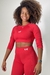 Modelo usando um top manga longa vermelho da coleção Garnet, com cabelo cacheado e sorriso! Roupas fitness para presente de natal com as promoções de Black Friday 
