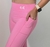 Calça leggings rosa com detalhe de bolso, modelo feminino, ideal para atividades físicas.