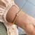Bracelete torcido dourado banhado a ouro com detalhe em zircôni