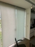 Cortina persiana rolô translúcida em um ambiente interno, exibindo sua cor clara e design moderno.