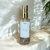 Frasco de aromatizador HOME SPRAY Conexão Interior com design elegante, contendo cristais de ametista, e aroma fresco de bamboo.