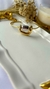 Bracelete Passali em semijoia com detalhe prateado, em fundo neutro com flores secas e vela ao fundo. Banhado a ouro 18k e Ródio Branco. MW Semijoias e Acessórios