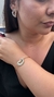Mulher usando um bracelete semijoia Barigota e brincos combinando, ambos com design elegante e moderno. Banhado a ouro 18k e Ródio Branco. MW Semijoias e Acessórios