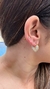Brinco argola em formato de coração com detalhes cravejados em cristal, usado na orelha de uma mulher. Banhado a ouro 18k. MW Semijoias e Acessórios