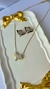 Colar Mapassa em semijoia com detalhes em pedras brilhantes, acompanhado de brincos que combinam, sobre um prato decorativo. Banhado a ouro 18k e Ródio Branco. MW Semijoias e Acessórios